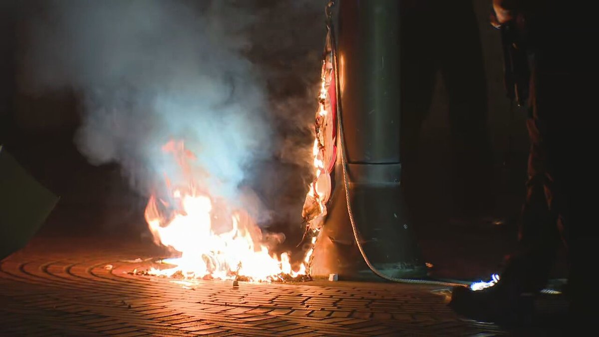 A second American flag was taken down and burned on the east side of the federal building. (Intersection of 1st Ave and Madison)
